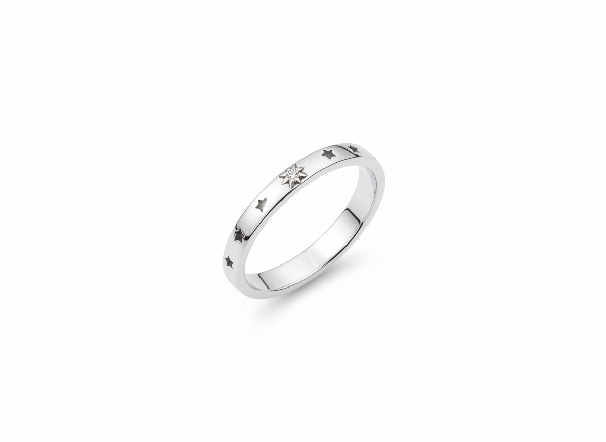 A silver band ring featuring small engraved star motifs and a central clear gemstone, shown on a plain white background.
